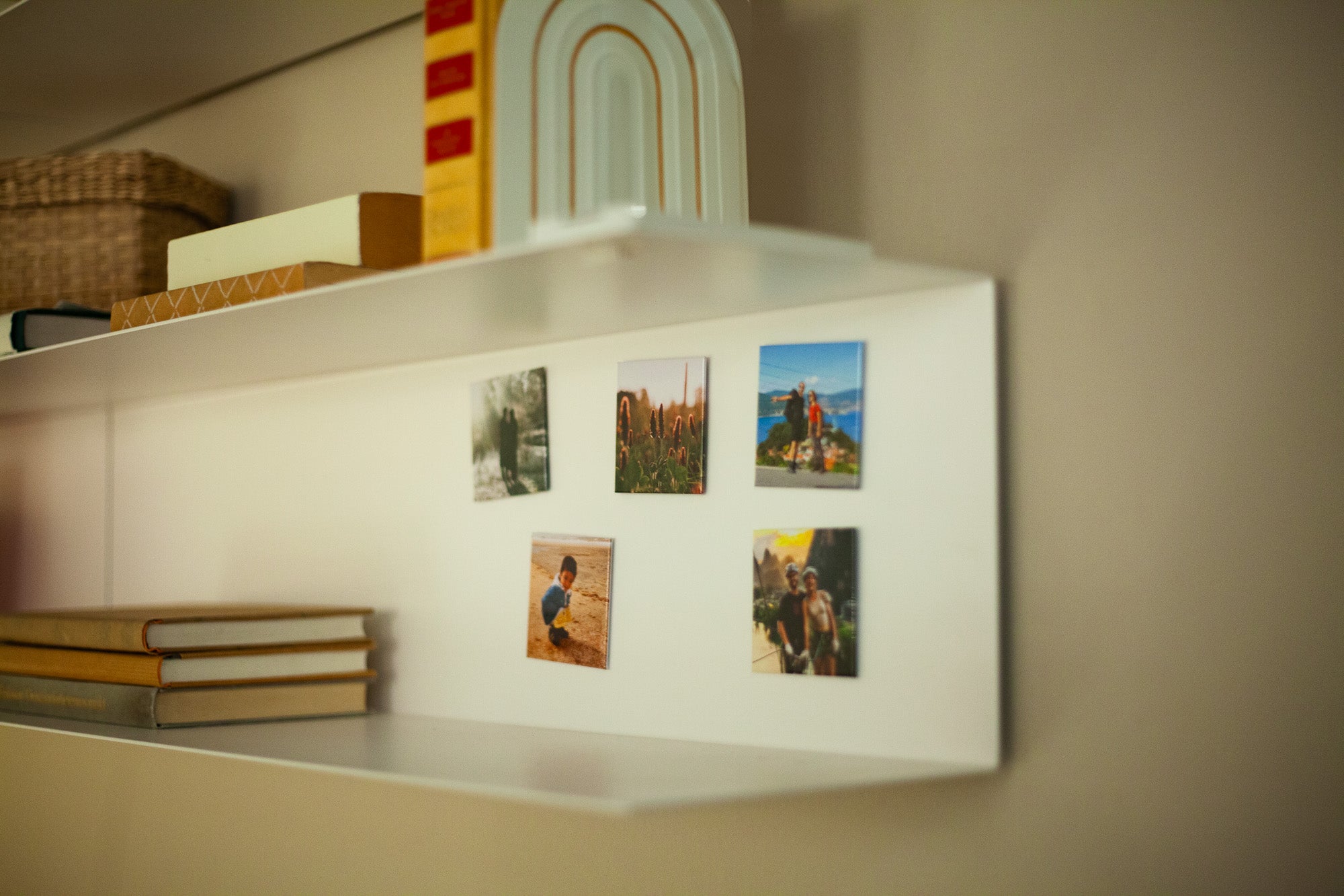 notjustmagnets. – 5 fotomagneten in een woonkamer, tegen een metalen schap naast boekenlose-up in woonruimte, medium close-up